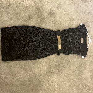 Black printed dress with gold belt and open back.